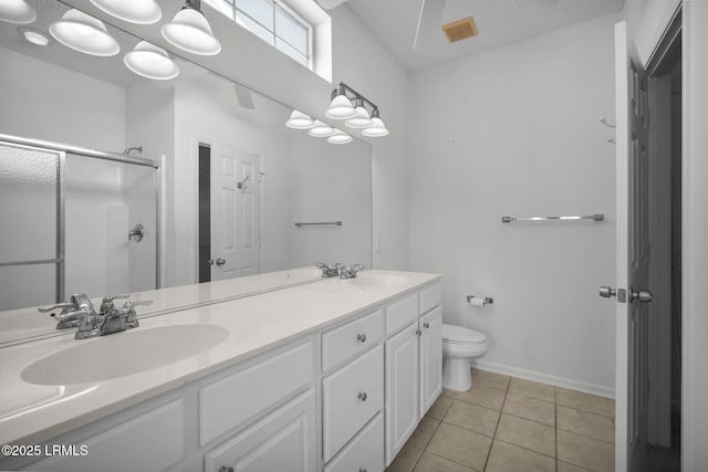 bathroom featuring vanity, a shower with door, tile patterned floors, and toilet