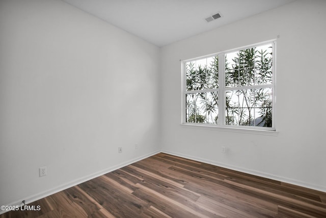 unfurnished room with dark wood-type flooring and plenty of natural light