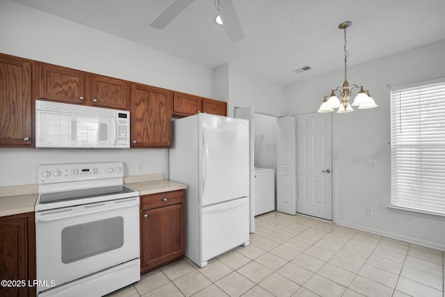 kitchen with light tile patterned floors, white appliances, hanging light fixtures, a textured ceiling, and ceiling fan with notable chandelier