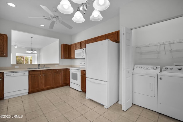 kitchen featuring pendant lighting, sink, white appliances, washer and clothes dryer, and ceiling fan with notable chandelier