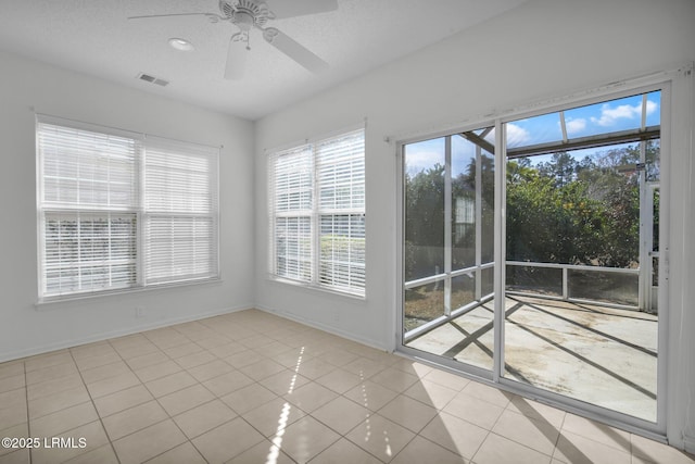 unfurnished sunroom with ceiling fan