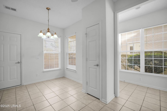 unfurnished dining area featuring an inviting chandelier and light tile patterned floors