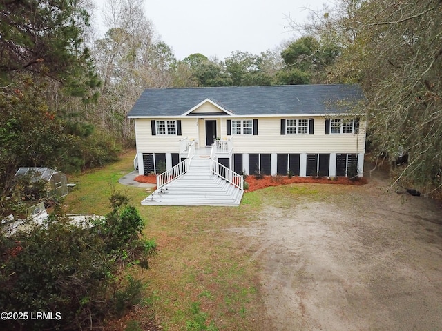 view of front of home with stairs, driveway, and a front yard