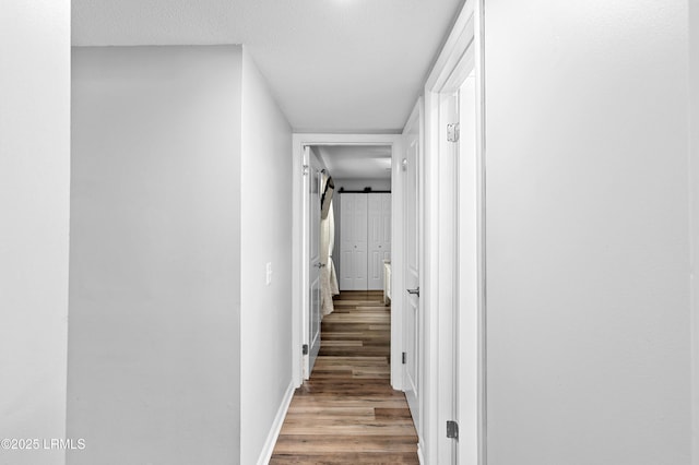 4018 Shell Point Rd, Beaufort, SC 29906 - corridor with wood finished floors, baseboards, a barn door, and a textured ceiling