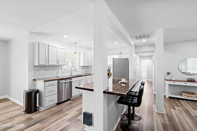 4018 Shell Point Rd, Beaufort, SC 29906 - kitchen featuring appliances with stainless steel finishes, a sink, wood counters, light wood-type flooring, and recessed lighting