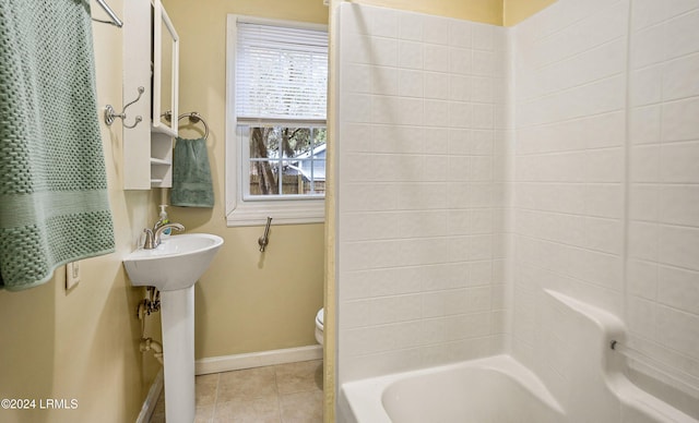 bathroom with tile patterned flooring, bathing tub / shower combination, and toilet