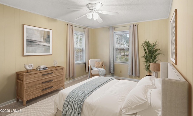 carpeted bedroom featuring a textured ceiling, ornamental molding, and ceiling fan