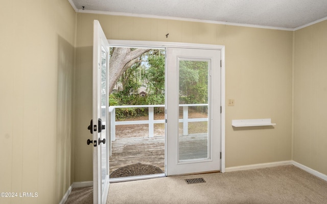 doorway featuring ornamental molding, carpet flooring, and a textured ceiling