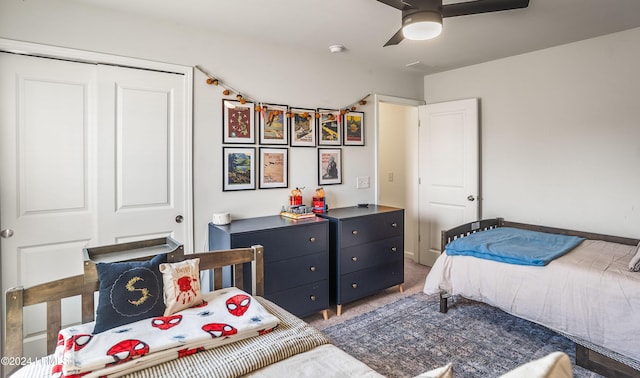 carpeted bedroom with ceiling fan and a closet