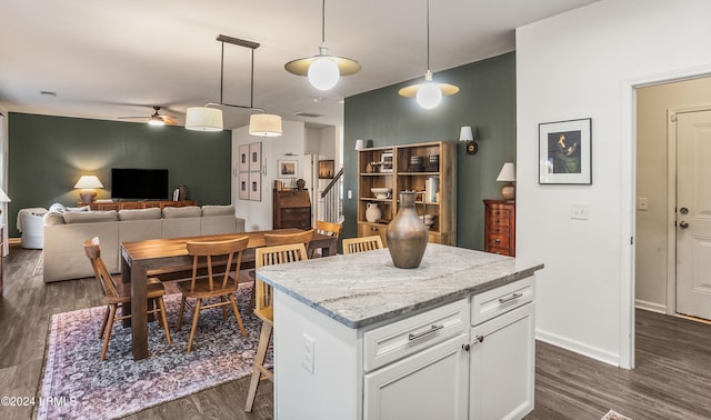 kitchen with white cabinetry, a kitchen bar, decorative light fixtures, and a kitchen island