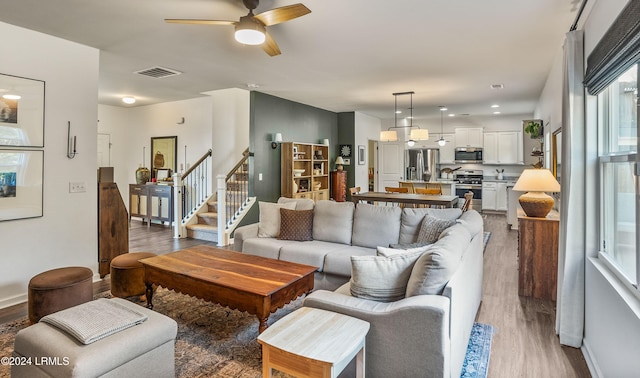 living room with wood-type flooring and ceiling fan