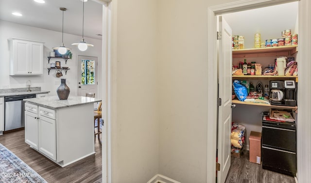 kitchen with decorative light fixtures, stainless steel dishwasher, white cabinets, and a kitchen island