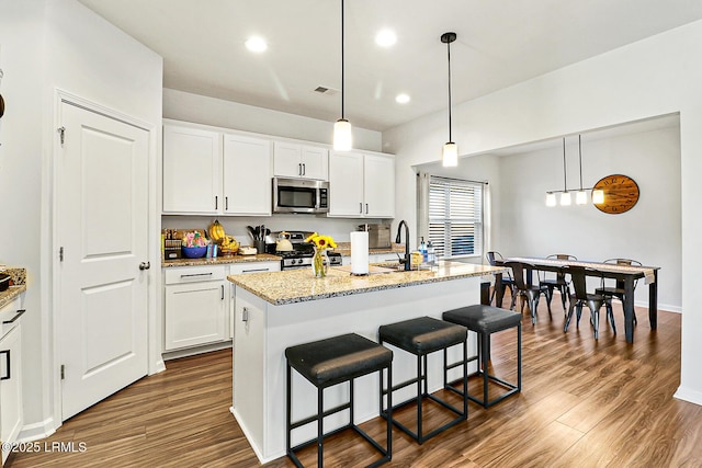 32 Chinquapin St, Beaufort, SC 29906 - kitchen featuring stainless steel microwave, dark wood-style flooring, stove, and white cabinets