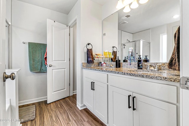 32 Chinquapin St, Beaufort, SC 29906 - bathroom with double vanity, wood finished floors, a sink, baseboards, and a stall shower