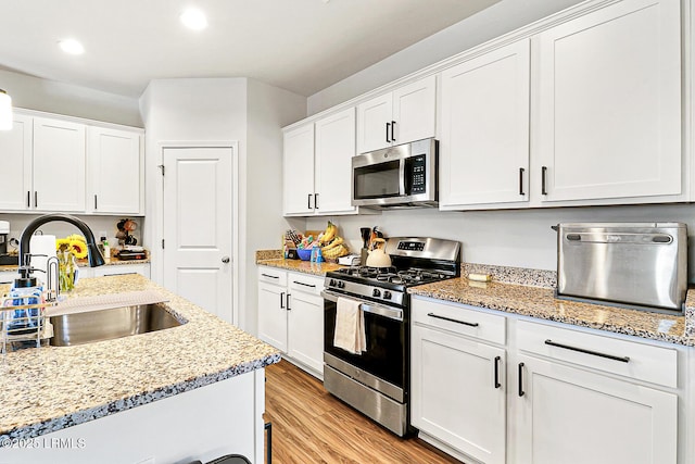 32 Chinquapin St, Beaufort, SC 29906 - kitchen with light wood-style floors, appliances with stainless steel finishes, white cabinetry, and a sink