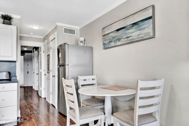 dining space featuring dark hardwood / wood-style flooring and crown molding