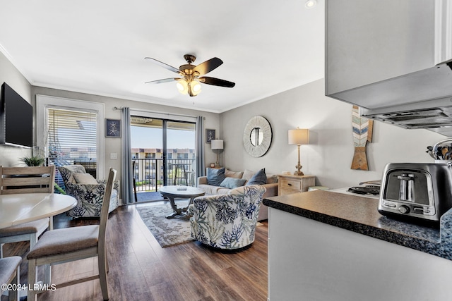 living room with crown molding, dark hardwood / wood-style floors, and ceiling fan