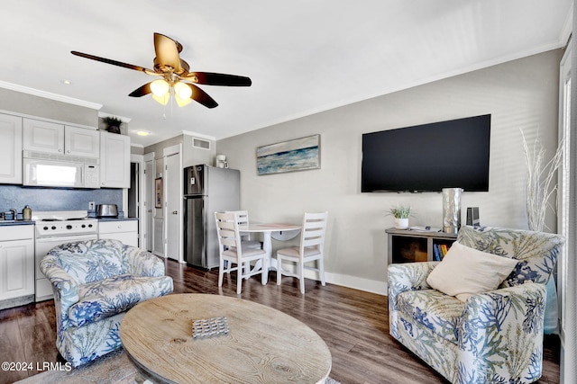 living room with dark hardwood / wood-style flooring, ornamental molding, and ceiling fan