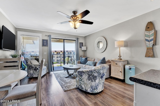 living room featuring hardwood / wood-style floors, ornamental molding, and ceiling fan