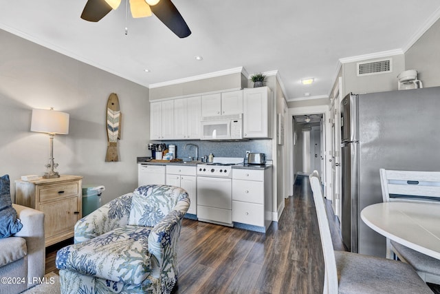 kitchen featuring dark hardwood / wood-style floors, sink, white cabinets, decorative backsplash, and white appliances