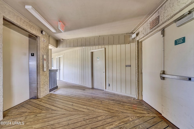 empty room with crown molding, parquet flooring, and elevator