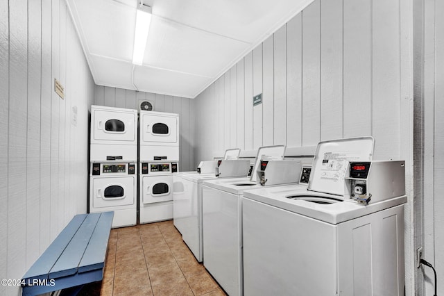 washroom with wood walls, stacked washer / dryer, separate washer and dryer, and light tile patterned floors