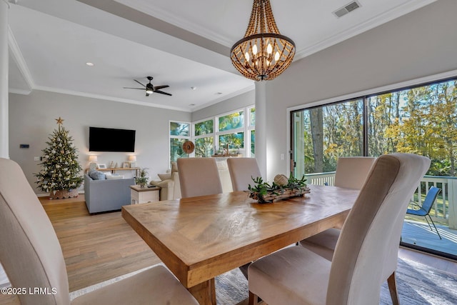 dining room featuring ceiling fan with notable chandelier, ornamental molding, and light wood-type flooring