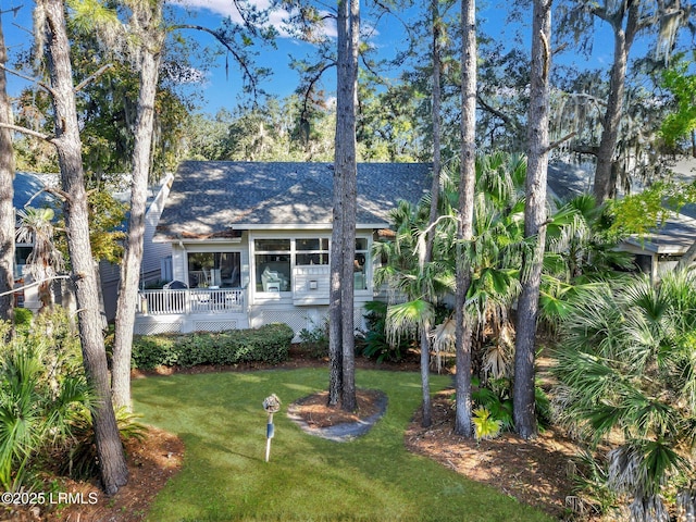 view of front facade with a wooden deck and a front yard