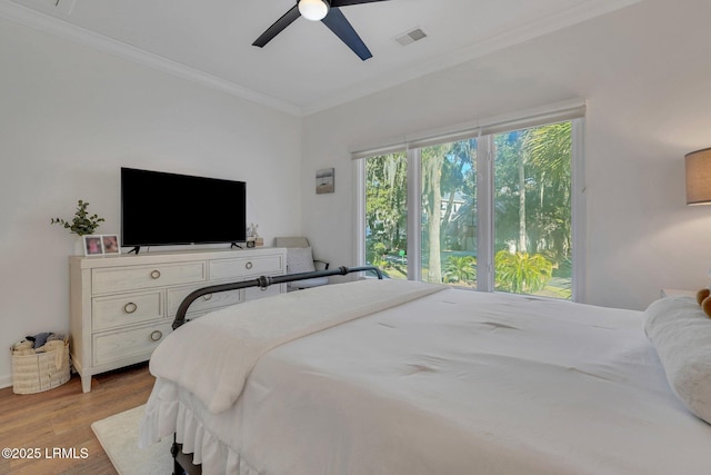 bedroom featuring ornamental molding, ceiling fan, and light hardwood / wood-style floors