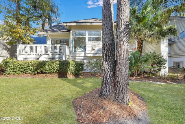 view of front of home with a front yard and a deck