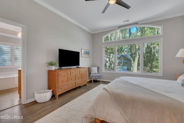 bedroom with dark hardwood / wood-style flooring, crown molding, ensuite bathroom, and ceiling fan