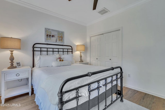 bedroom featuring crown molding, light hardwood / wood-style floors, a closet, and ceiling fan