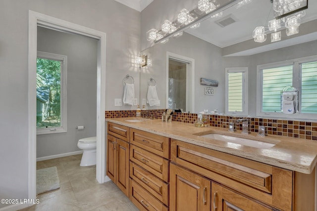 bathroom with vanity, decorative backsplash, and toilet