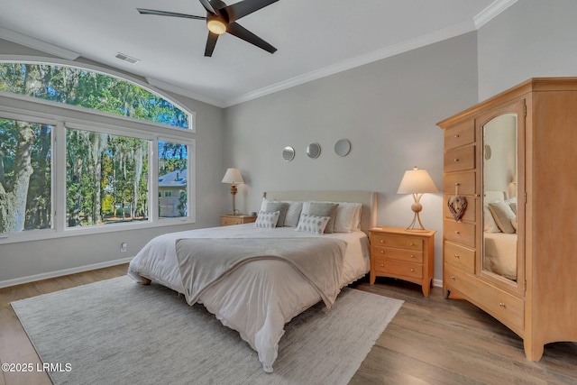 bedroom with wood-type flooring, vaulted ceiling, ornamental molding, and ceiling fan