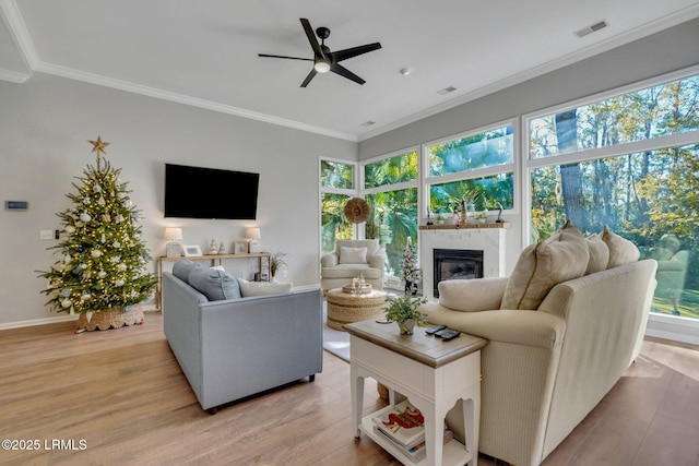 living room with crown molding, ceiling fan, and light hardwood / wood-style floors