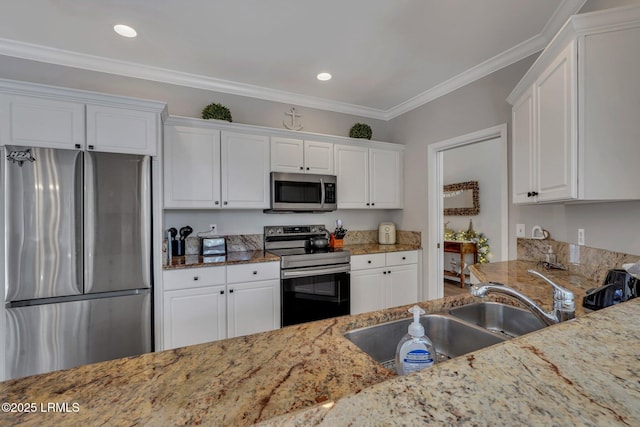 kitchen with light stone countertops, appliances with stainless steel finishes, sink, and white cabinets