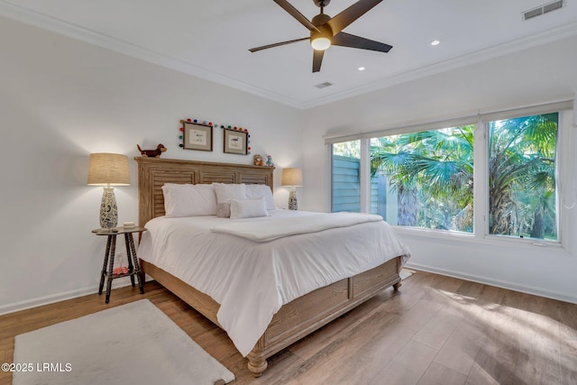 bedroom with wood-type flooring, ornamental molding, and ceiling fan