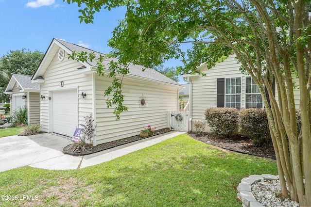 10 Rockville Way, Beaufort, SC 29902 - view of side of home with roof with shingles, a yard, a garage, driveway, and an outdoor structure