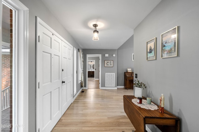 interior space featuring light wood-style floors, visible vents, and baseboards