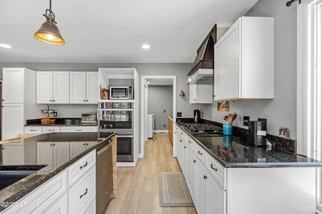 kitchen with stainless steel appliances, hanging light fixtures, light wood-type flooring, and white cabinetry