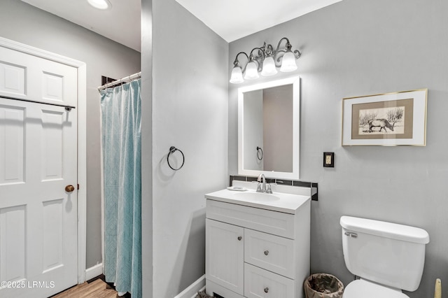 full bathroom with toilet, curtained shower, baseboards, and vanity