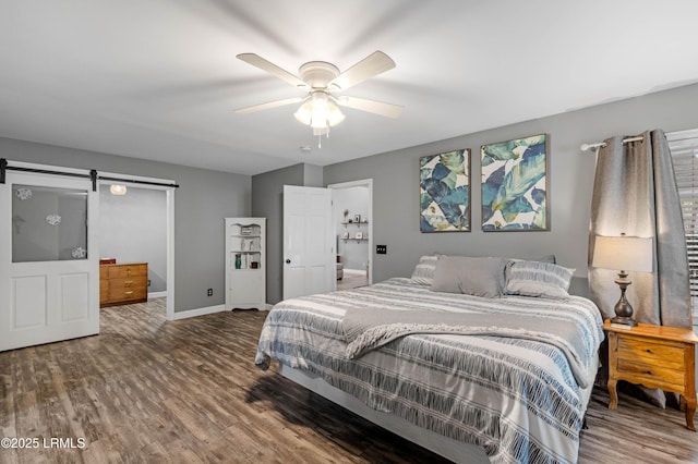 bedroom with a ceiling fan, wood finished floors, baseboards, and a barn door