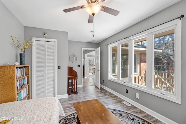 bedroom featuring visible vents, baseboards, a closet, and wood finished floors