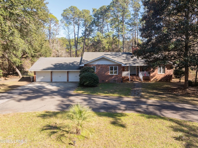 view of front of property featuring driveway, a garage, brick siding, crawl space, and a front yard