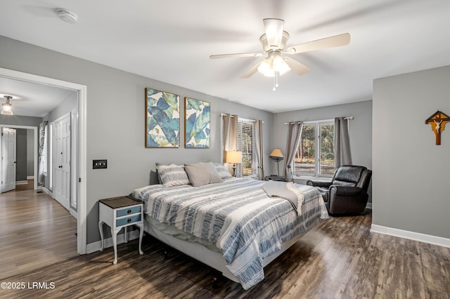 bedroom with ceiling fan, baseboards, and wood finished floors