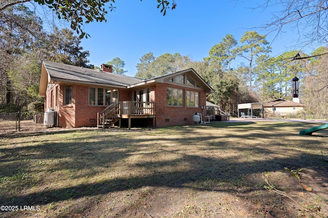 back of property featuring crawl space, fence, a lawn, and brick siding