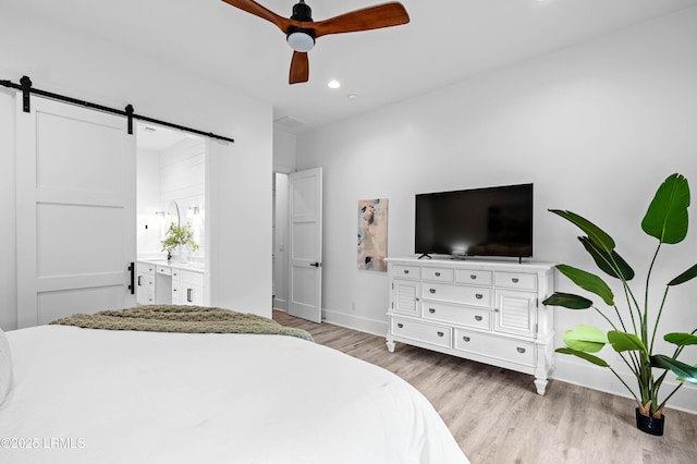 1014 Ferrets End, Beaufort, SC 29902 - bedroom with a barn door, wood finished floors, baseboards, recessed lighting, and ensuite bathroom