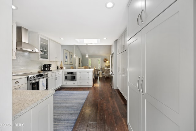8 Bradley Beach Rd, Hilton Head Island, SC 29928 - kitchen featuring wall chimney range hood, a peninsula, stainless steel appliances, a skylight, and light countertops