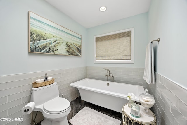 8 Bradley Beach Rd, Hilton Head Island, SC 29928 - bathroom featuring tile walls, a soaking tub, toilet, wainscoting, and recessed lighting