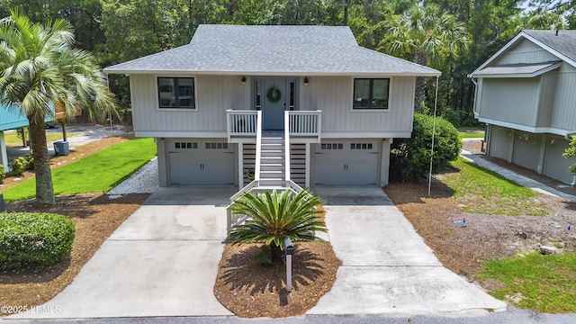 8 Bradley Beach Rd, Hilton Head Island, SC 29928 - coastal home with roof with shingles, an attached garage, concrete driveway, stairs, and covered porch